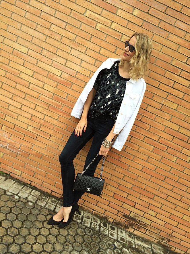 María León con jeans de Acne, top estampado de Sandro, chaqueta vaquera blanca de PDH Sport, bolso 2.55 de Chanel, pulseras Indias, pendiente de Thomas Sabo, gafas de sol Ray Ban y tacones de Massimo Dutti.