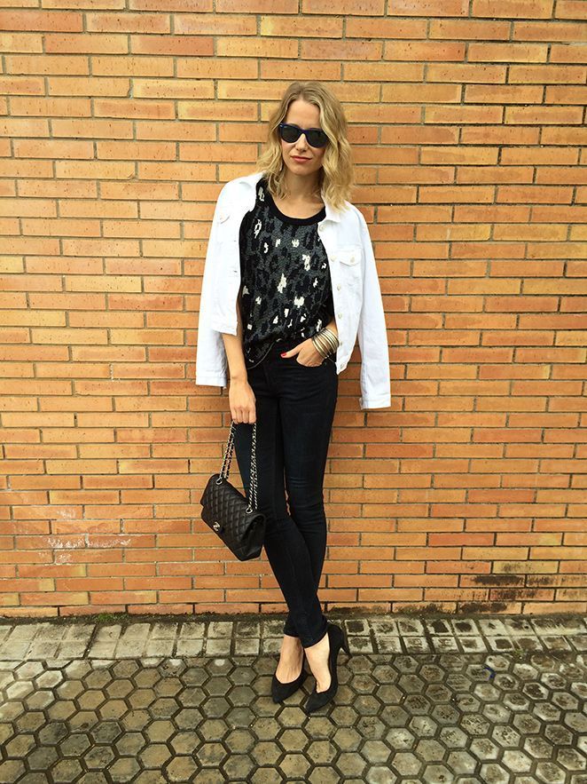 María León con jeans de Acne, top estampado de Sandro, chaqueta vaquera blanca de PDH Sport, bolso 2.55 de Chanel, pulseras Indias, pendiente de Thomas Sabo, gafas de sol Ray Ban y tacones de Massimo Dutti.
