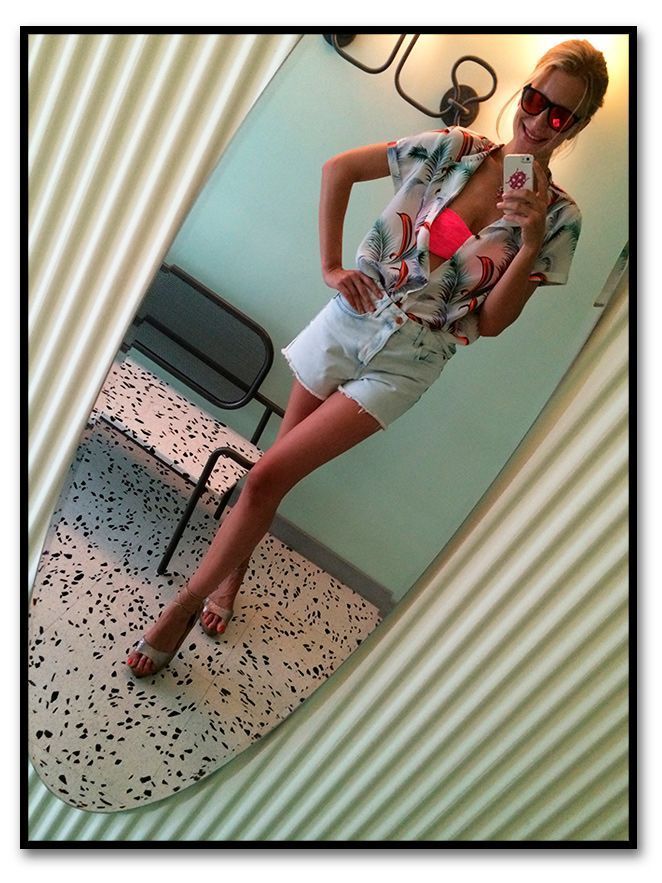 María León con look de shorts de TopShop, camisa de Scoth&Soda para Papaya, cuñas de esparto de Castañer, bolsa de flamencos de Pinkoco, suti bandeau fucsia de Pink y gafas de Life Italia