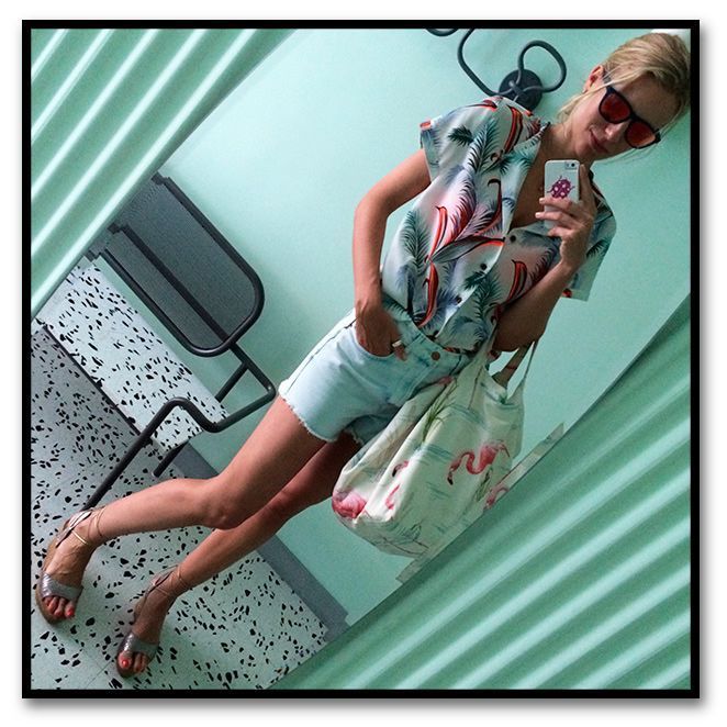 María León con look de shorts de TopShop, camisa de Scoth&Soda para Papaya, cuñas de esparto de Castañer, bolsa de flamencos de Pinkoco, suti bandeau fucsia de Pink y gafas de Life Italia
