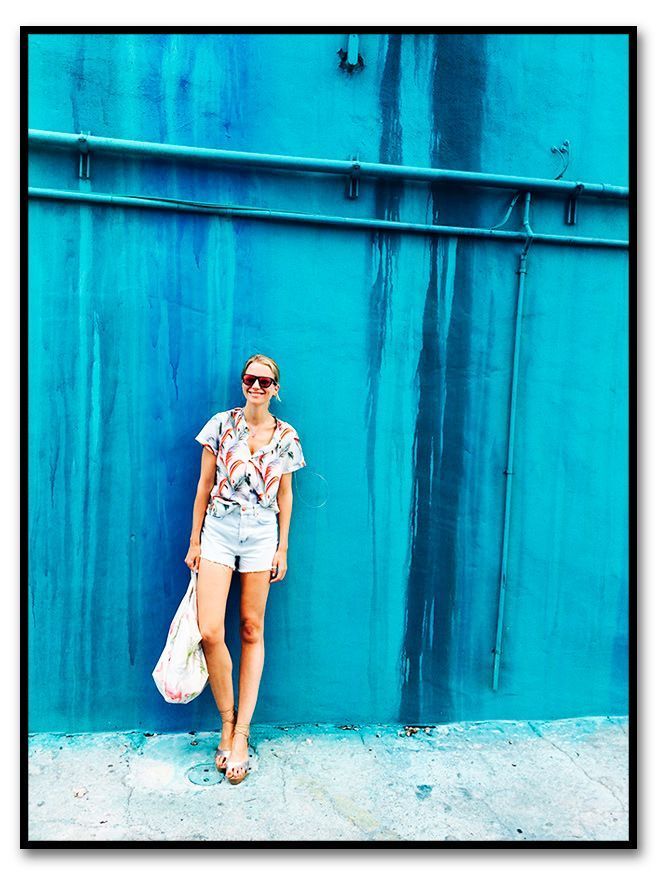 María León con look de shorts de TopShop, camisa de Scoth&Soda para Papaya, cuñas de esparto de Castañer, bolsa de flamencos de Pinkoco, suti bandeau fucsia de Pink y gafas de Life Italia