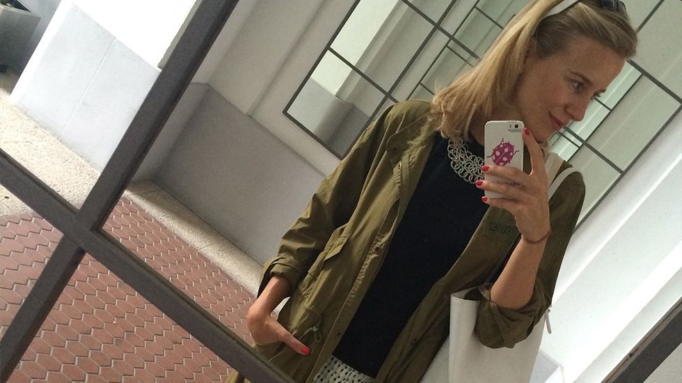 María León con look de verano con falda de Soy una chica normal que combiné con camiseta negra de Mango, collar de Pedro del Hierro, parka impermeable de Zara, botas Hunter, bolso de Pedro del Hierro y gafas Ray Ban.